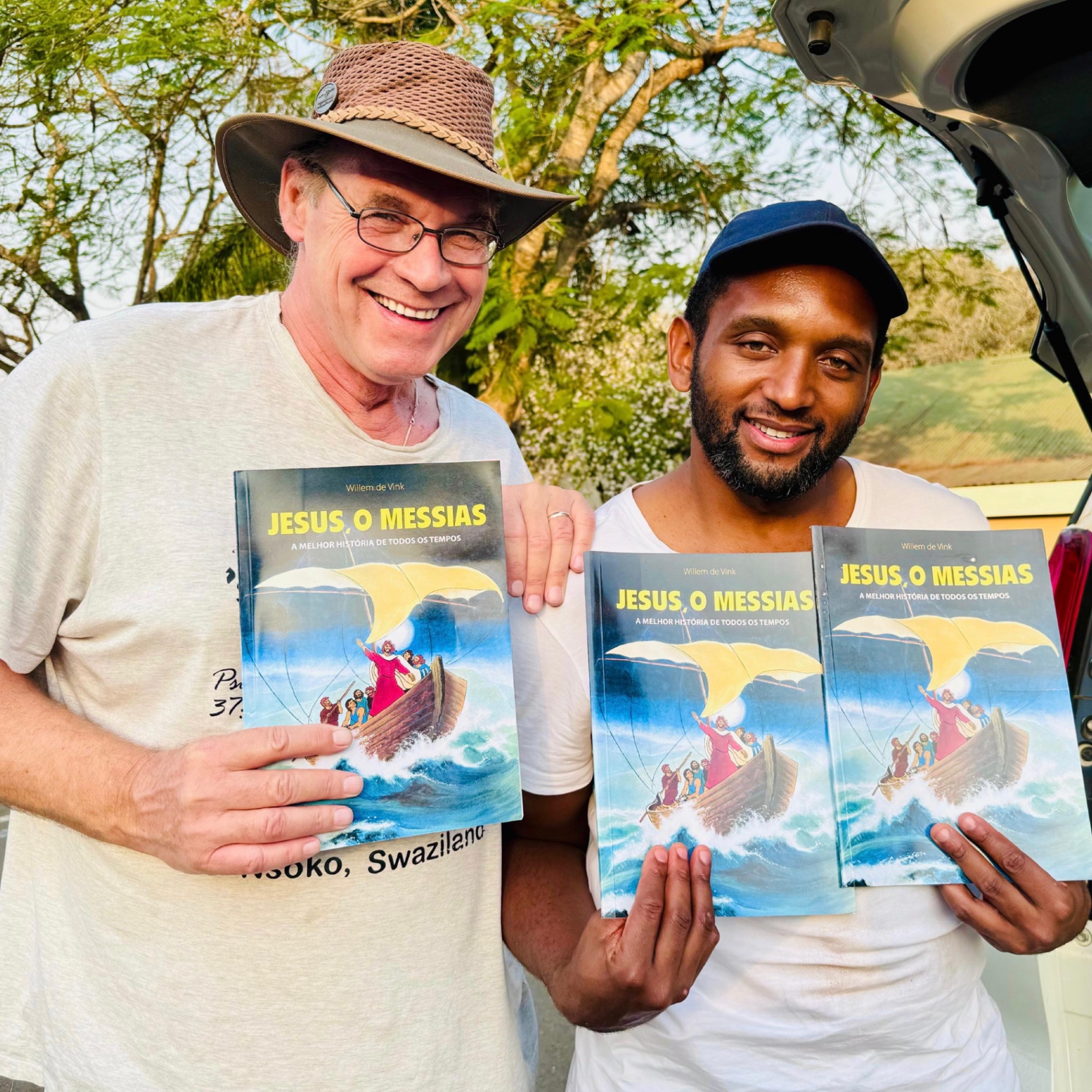 Leo Baan en een Swazi medewerker met Portugese edities van Jezus de Messias bij Nsoko, Eswatini