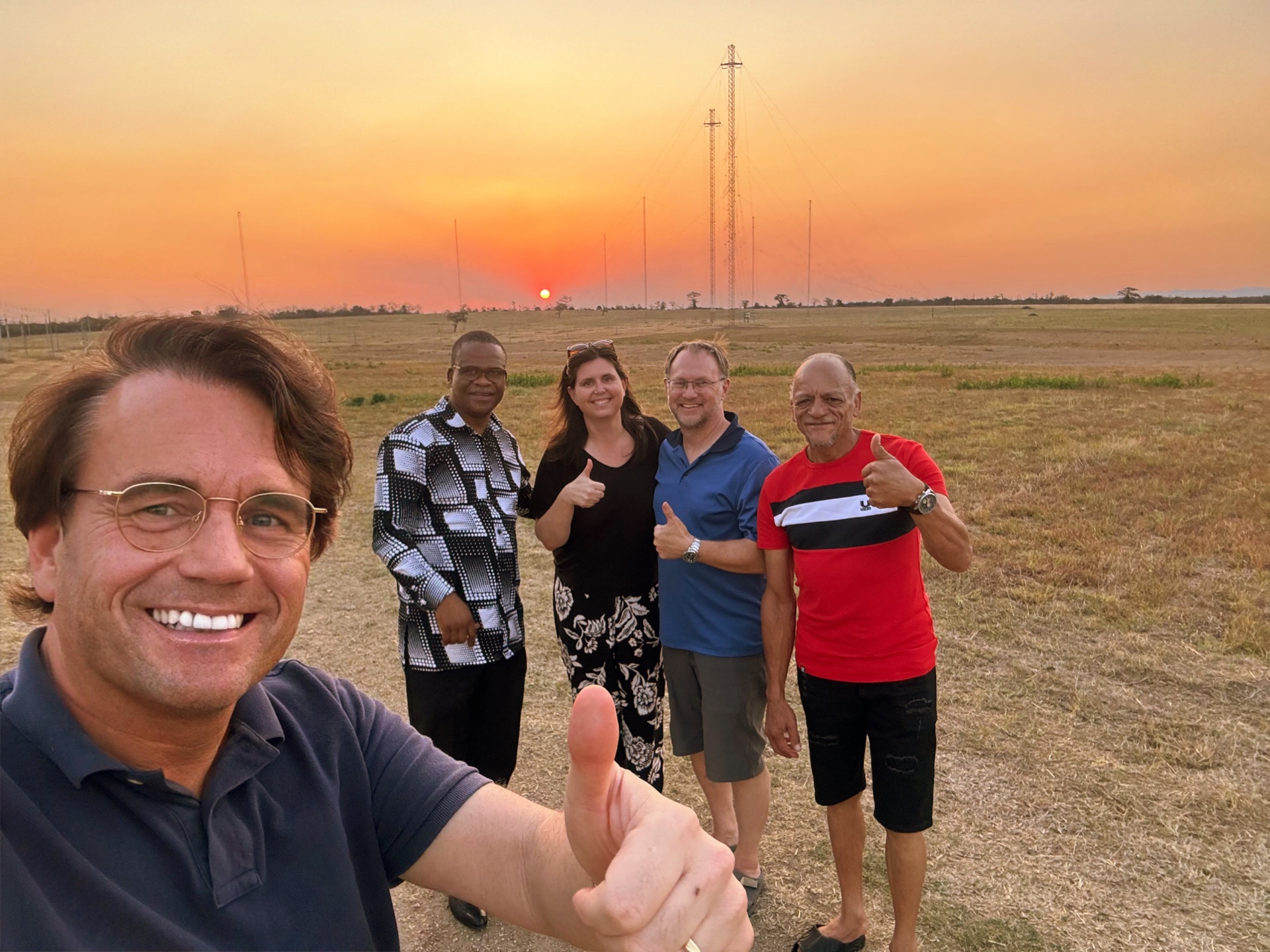 Team van TWR Eswatini en Bas Emons voor de zendmasten bij zonsondergang