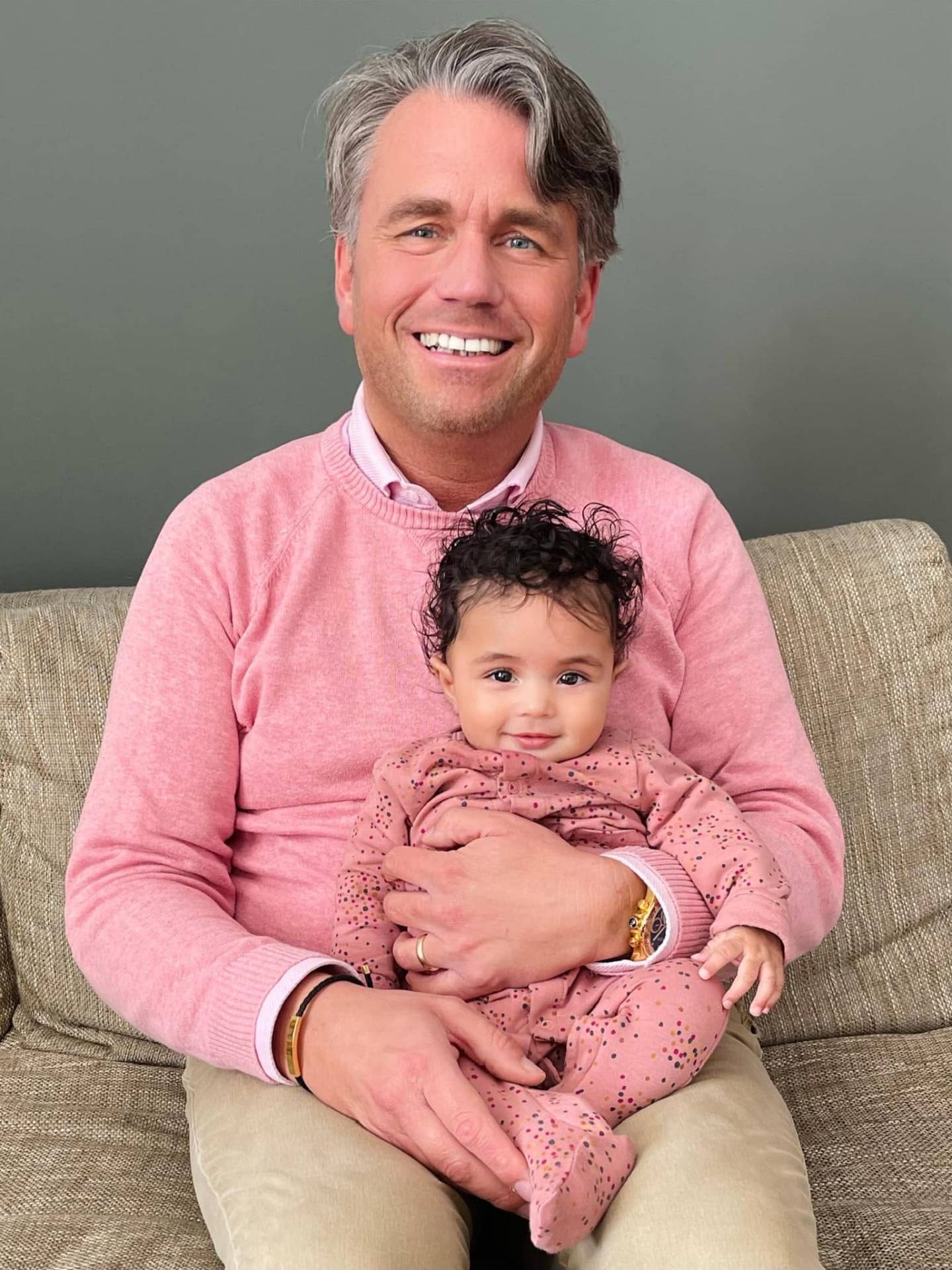 Bas met Hope als baby op schoot — beiden in het roze, pure liefde.