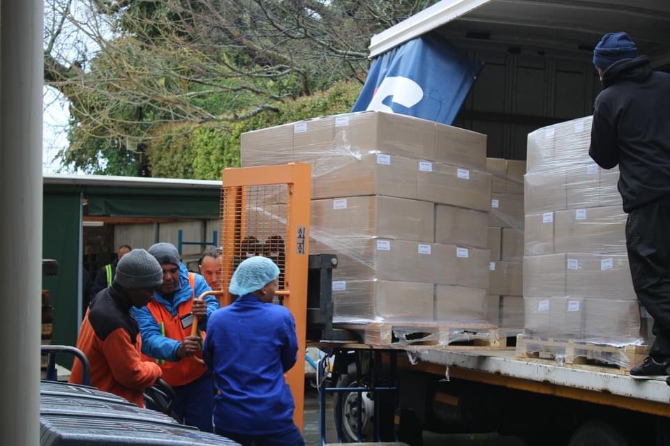 Pallets met Jezus de Messias worden in een vrachtwagen geladen voor transport naar Afrika